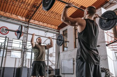 İki sporcu spor salonunda ağırlık togethrt kaldırma.