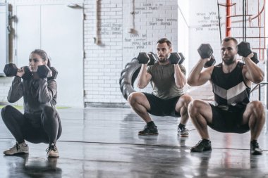 Grup sporcular ve spor salonunda ağırlık ile ağız kavgası yapıyor sportswomen.