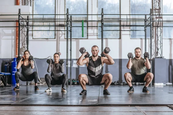 Grupo Deportistas Haciendo Sentadillas Con Pesas Gimnasio — Foto de Stock