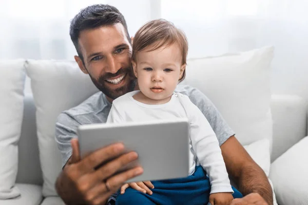 Stilig Kaukasiska Man Hålla Sonen Söt Baby Och Tittar Surfplatta — Stockfoto