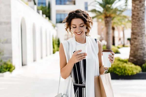 Όμορφη Χαμογελαστή Shopper Γυναίκα Καυκάσιος Πληκτρολόγηση Smartphone Της Και Κρατώντας — Φωτογραφία Αρχείου