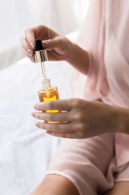 Kozmetik serum ile şişe tutan unrecognisable kadın elinde.