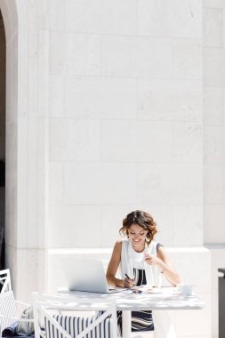 Kahve dükkanında oturmuş ve onun not defterinde yazma oldukça beyaz şık kadın.