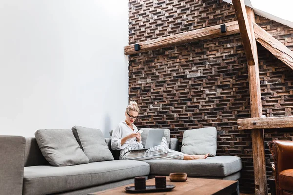 Hübsche Blonde Kaukasierin Sitzt Auf Der Couch Und Tippt Auf — Stockfoto