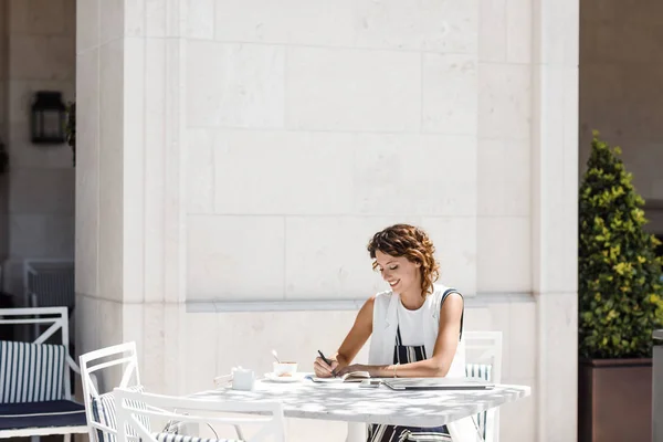Αρκετά Καυκάσιος Γυναίκα Κάθεται Στο Καφενείο Και Γράφοντας Στο Τετράδιο — Φωτογραφία Αρχείου