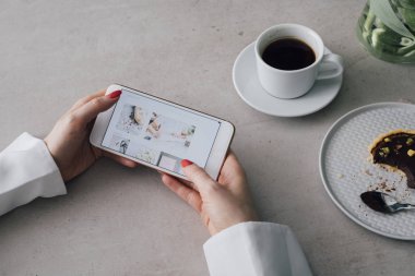 Cep telefonunu kullanan unrecognisable kadın elinde fotoğraf yukarıda.