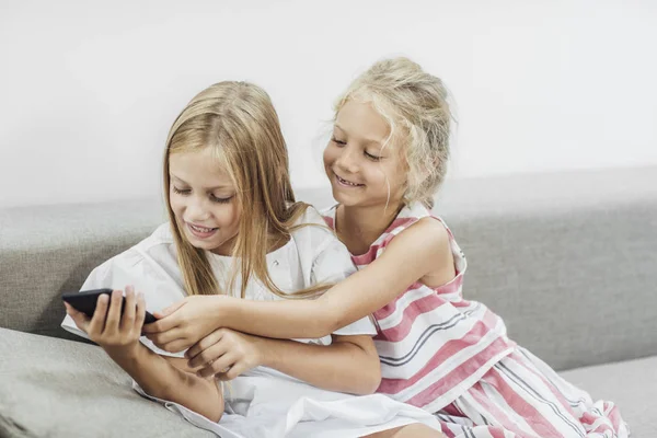 Duas Lindas Meninas Brancas Irmãs Sentadas Casa Olhando Para Telefone — Fotografia de Stock