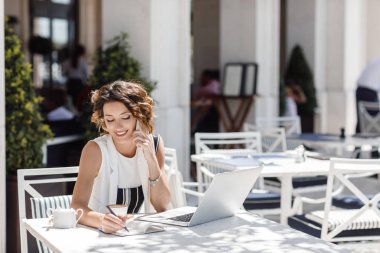 Onu cep telefonundan konuşuyor ve kahve dükkanında çalışan güzel şık gülümseyen beyaz bir kadın.