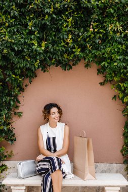 Bahçe bankta oturan oldukça beyaz gülümseyen kadın.