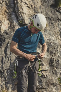 Onun tırmanma equpipment hazırlanması ve açık havada duran erkek dağcı.