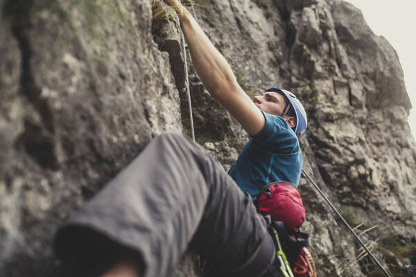 A man climbing an outdoor natural rock.