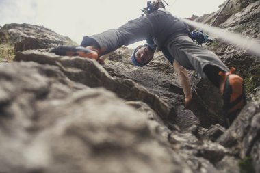 Aşağıdan bir adamın fotoğraf bir kaya tırmanışı.