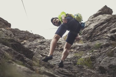 Bir adam bir kaya tırmanma tırmanıcı fotoğraf aşağıdan.