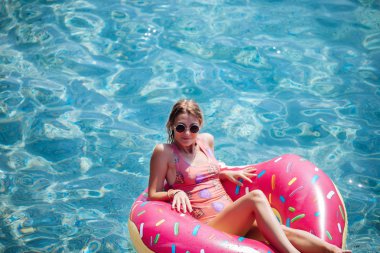 Güzel kadın Akdeniz ve zevk üzerinde kayan halka yatan güneşlenmek.