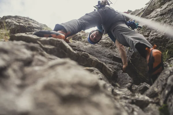 Aşağıdan bir adamın fotoğraf bir kaya tırmanışı.