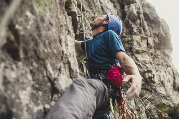 A man climbing an outdoor natural rock.