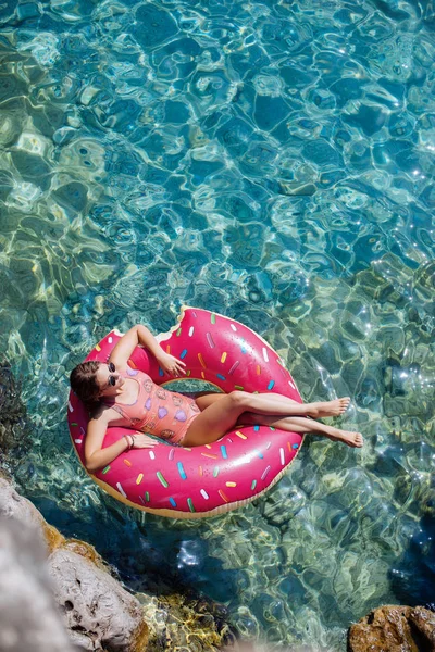 Güzel kadın Akdeniz ve zevk üzerinde kayan halka yatan güneşlenmek.