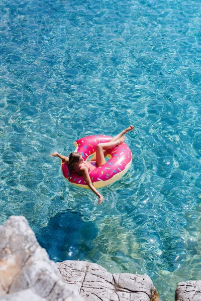 Güzel kadın Akdeniz ve zevk üzerinde kayan halka yatan güneşlenmek.