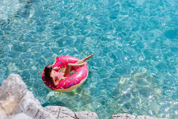 Güzel kadın Akdeniz ve zevk üzerinde kayan halka yatan güneşlenmek.
