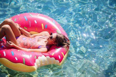 Güzel kadın Akdeniz ve zevk üzerinde kayan halka yatan güneşlenmek.