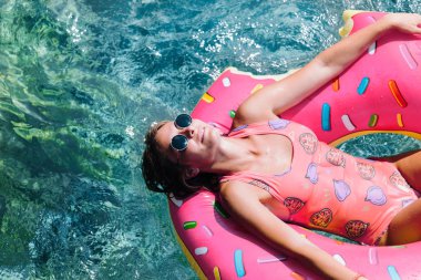 Güzel kadın Akdeniz ve zevk üzerinde kayan halka yatan güneşlenmek.