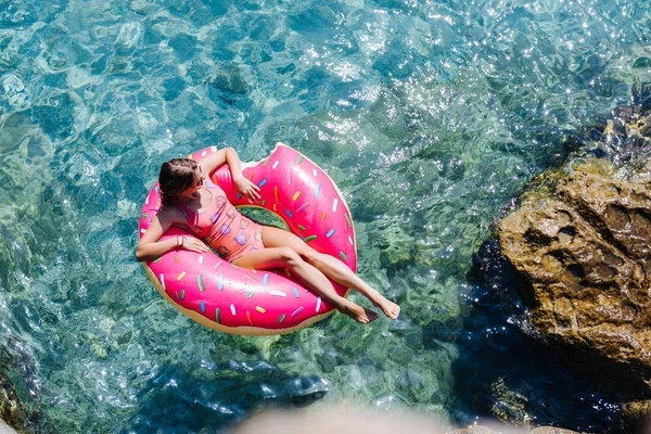 Güzel kadın Akdeniz ve zevk üzerinde kayan halka yatan güneşlenmek.