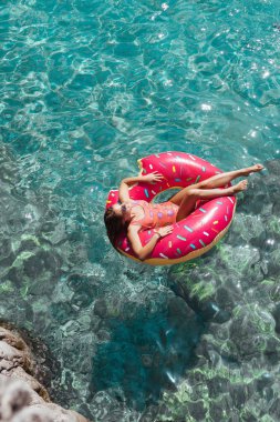 Güzel kadın Akdeniz ve zevk üzerinde kayan halka yatan güneşlenmek.