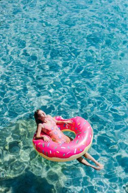 Güzel kadın Akdeniz ve zevk üzerinde kayan halka yatan güneşlenmek.