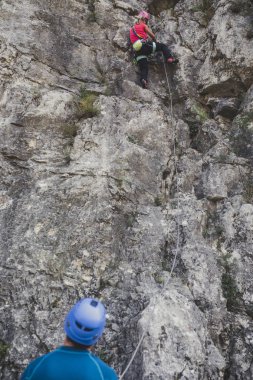 Erkek ve kadın dağcılar açık havada doğal kaya tırmanışı.