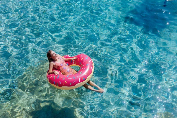 Güzel kadın Akdeniz ve zevk üzerinde kayan halka yatan güneşlenmek.