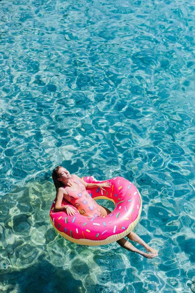 Güzel kadın Akdeniz ve zevk üzerinde kayan halka yatan güneşlenmek.