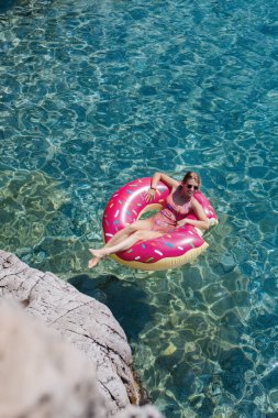 Güzel kadın Akdeniz ve zevk üzerinde kayan halka yatan güneşlenmek.
