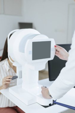 Ophatlmology sınav için tıbbi teknoloji kullanarak unrecognisable kadın doktor eller.