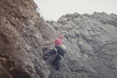 Bir kadın dağcı dağın kaya tırmanışı.