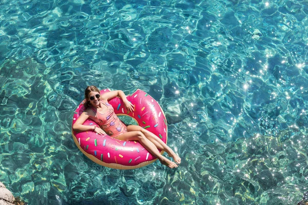 Güzel kadın Akdeniz ve zevk üzerinde kayan halka yatan güneşlenmek.