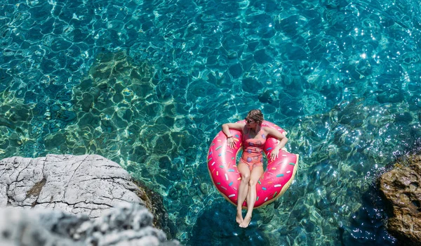Güzel kadın Akdeniz ve zevk üzerinde kayan halka yatan güneşlenmek.