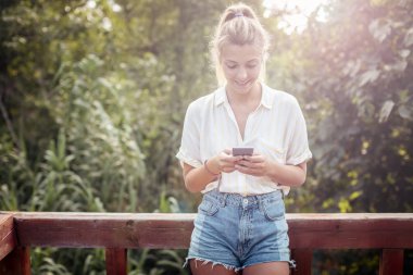 Açık havada duran ve cep telefonunu yazarak güzel rahat kafkas kadın beldedir.