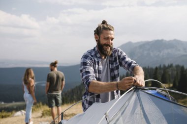 Bir grup genç insan çadır kamp için hazırlanıyor.