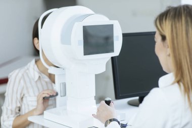 Bir kadın doktor Oftalmoloji onay için onu hasta yapıyor.