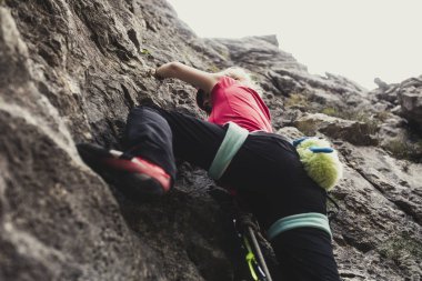 kadın alpinist bir kaya tırmanışı.