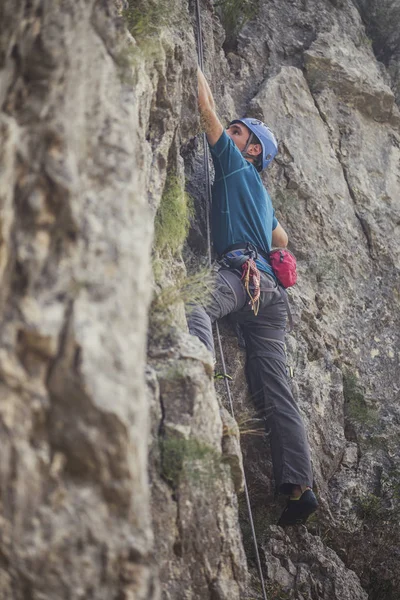 Profesyonel erkek dağcı bir kaya tırmanışı.