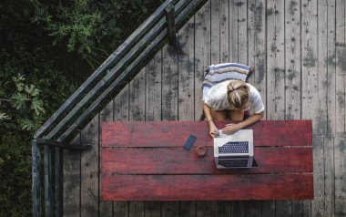 Genç businesswoaman ahşap terasta bir tatilde çalışma fotoğraf yukarıda.