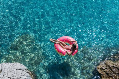 Güzel kadın Akdeniz ve zevk üzerinde kayan halka yatan güneşlenmek.
