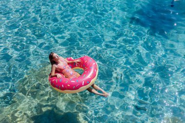 Güzel kadın Akdeniz ve zevk üzerinde kayan halka yatan güneşlenmek.