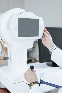 Ophatlmology sınav için tıbbi teknoloji kullanarak unrecognisable kadın doktor eller.