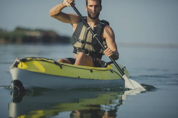 ハンサムな白人男性のカヤッカー川のパドリング — ストック写真