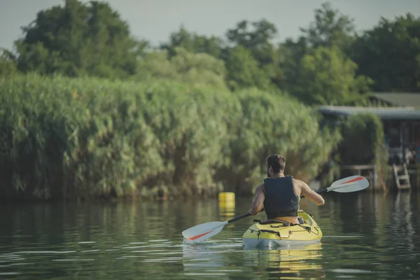 川の上を漕ぐ男カヤッカーの背面図 — ストック写真