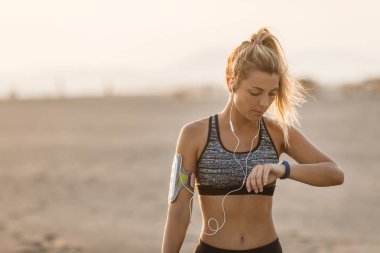 Kumsalda duran ve bakarak güzel beyaz kadın atlet.