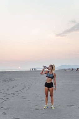 Kumsalda duran ve içme suyu güzel sporcumuz.