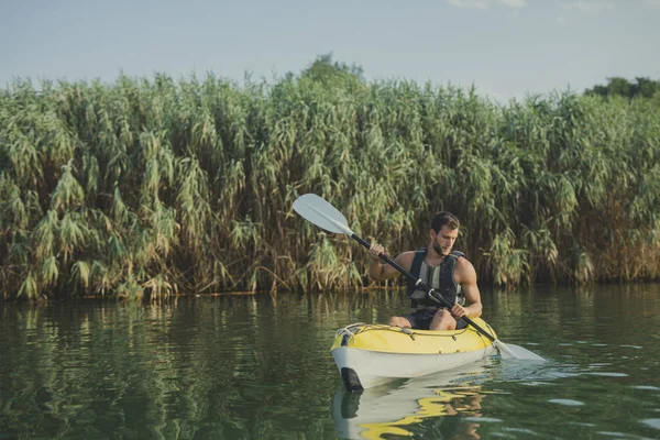 ハンサムな白人男性のカヤッカー川のパドリング — ストック写真